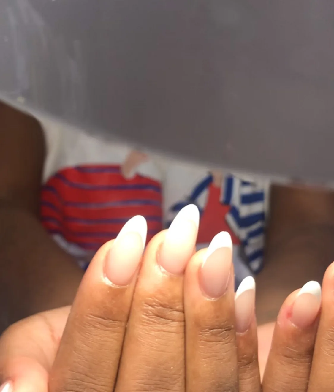 Ongles amande en dégradé babyboomer nude et blanc, sur peau foncée.