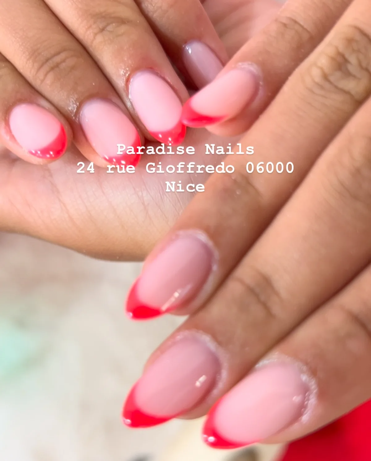 Ongles amande en french rouge vif, deux mains croisées.
