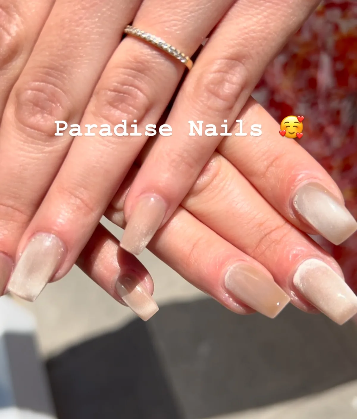 Ongles carrés longs en dégradé nude et blanc nacré, deux mains superposées.